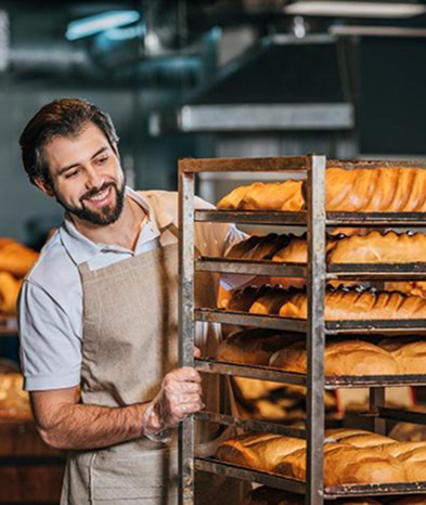 Baker man looks at the loaves with a smile